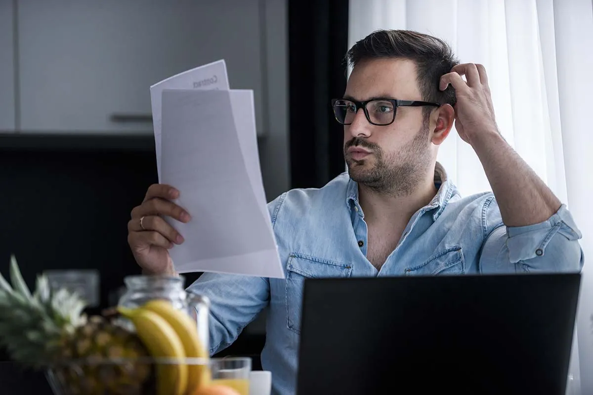 Young man looking at his tax bill and trying to understand it. understanding non-taxable events