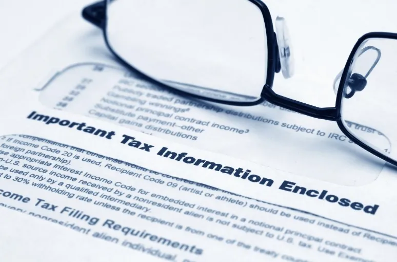 Glasses on paper with “Important Tax Information Enclosed”